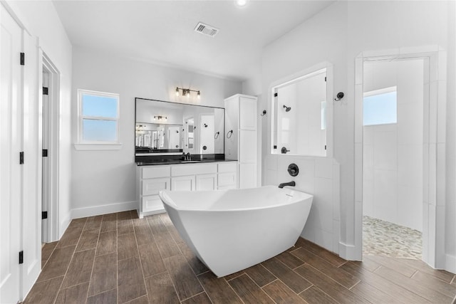 bathroom with shower with separate bathtub, vanity, and a wealth of natural light