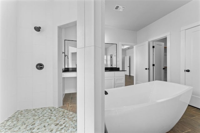 bathroom featuring hardwood / wood-style floors, vanity, and separate shower and tub