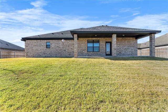 rear view of property featuring a yard