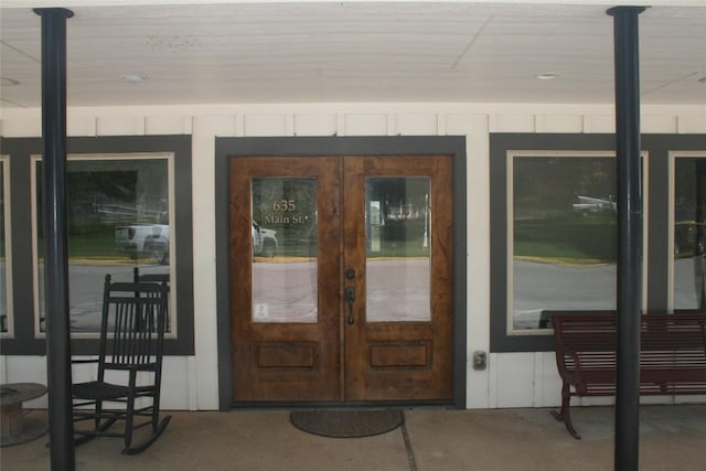 entrance to property with a porch and french doors