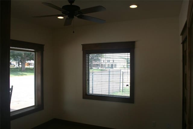 spare room with ceiling fan and plenty of natural light