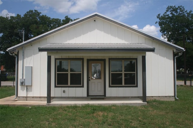 back of property with a yard and a porch