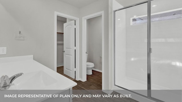 bathroom featuring hardwood / wood-style flooring, vanity, toilet, and a shower with door