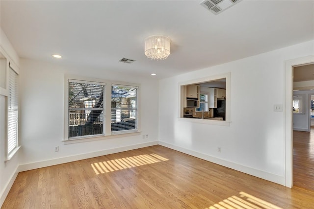 1721 Palma Plz, Austin, TX 78703 - empty room with a chandelier, wood finished floors, and recessed lighting