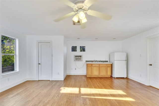 1721 Palma Plz, Austin, TX 78703 - kitchen featuring freestanding refrigerator, a wall unit AC, light wood-style floors, and light countertops