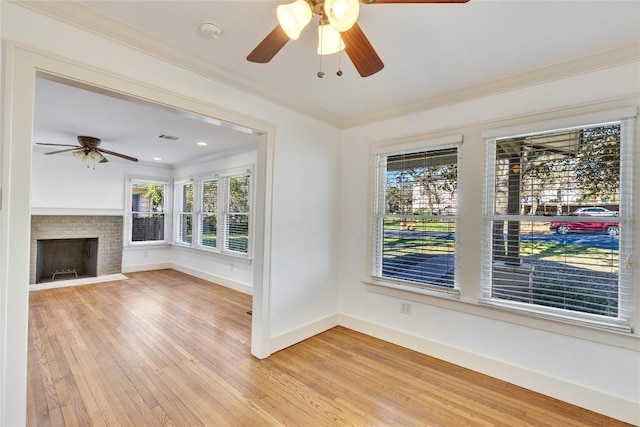 1721 Palma Plz, Austin, TX 78703 - unfurnished living room featuring ceiling fan, ornamental molding, light wood-style flooring, and a brick fireplace