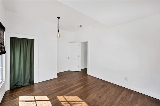 spare room featuring dark wood-type flooring