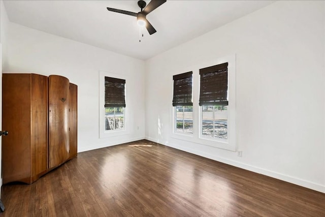 unfurnished room with ceiling fan and dark wood-type flooring