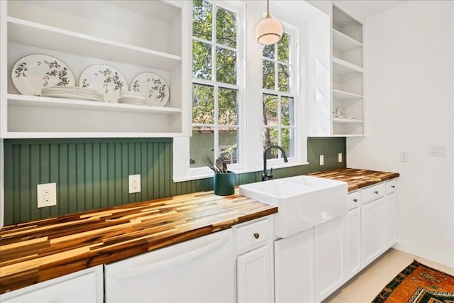 kitchen with white cabinetry, dishwasher, sink, wooden counters, and pendant lighting