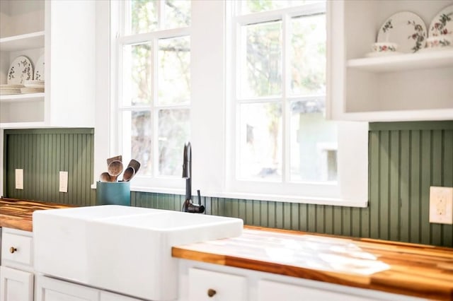 details featuring wooden counters, white cabinets, and sink