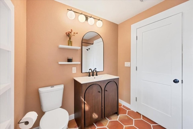 bathroom featuring tile patterned flooring, vanity, and toilet