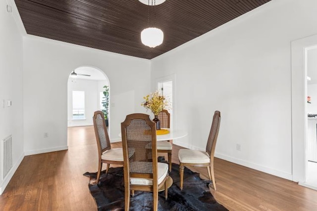 dining area featuring hardwood / wood-style floors, wood ceiling, and crown molding