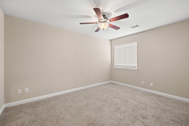 carpeted empty room with ceiling fan and a textured ceiling