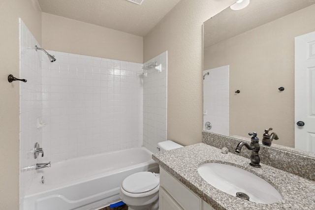 full bathroom featuring toilet, vanity, a textured ceiling, and tiled shower / bath combo