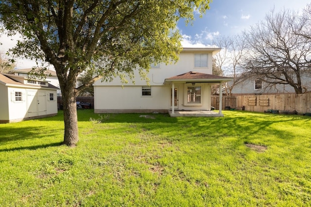 back of property featuring a yard and a shed