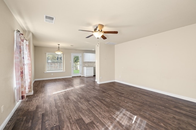 unfurnished living room featuring dark hardwood / wood-style flooring and ceiling fan