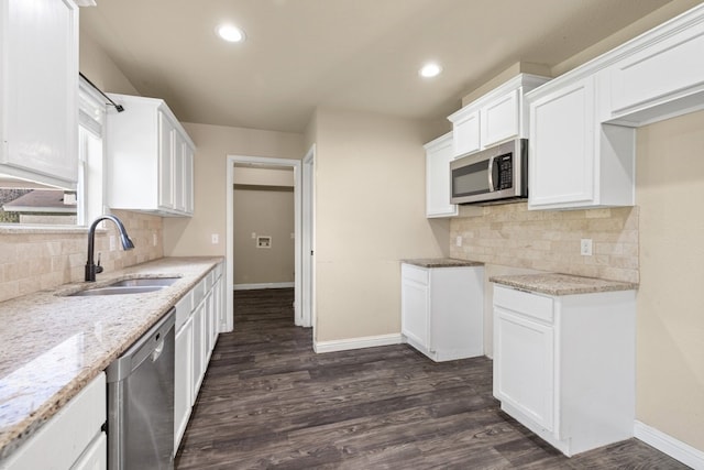 kitchen with white cabinets, appliances with stainless steel finishes, dark hardwood / wood-style flooring, and sink