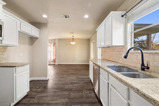 kitchen featuring light stone countertops, white cabinetry, sink, dark wood-type flooring, and decorative backsplash