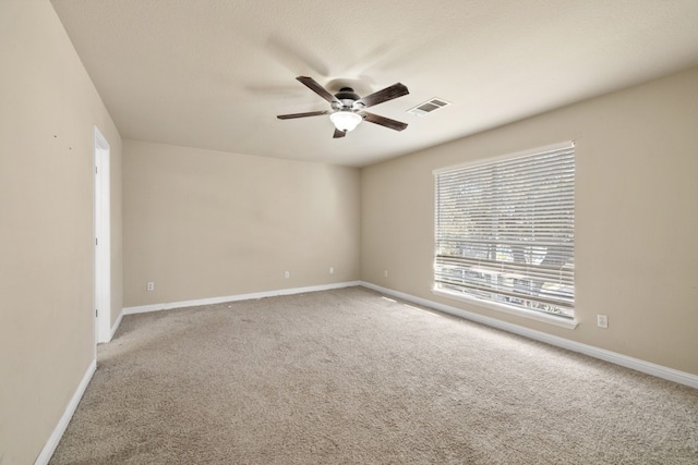 carpeted spare room with ceiling fan