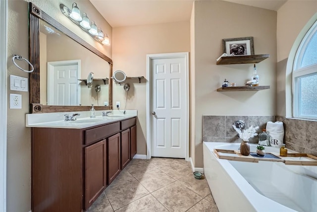 bathroom featuring tile patterned flooring, vanity, and a tub to relax in