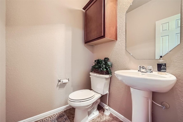 bathroom with tile patterned flooring, toilet, and sink