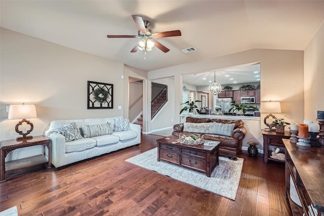 living room with dark hardwood / wood-style floors, ceiling fan with notable chandelier, and vaulted ceiling