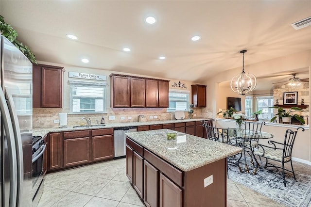 kitchen with decorative light fixtures, plenty of natural light, sink, and appliances with stainless steel finishes