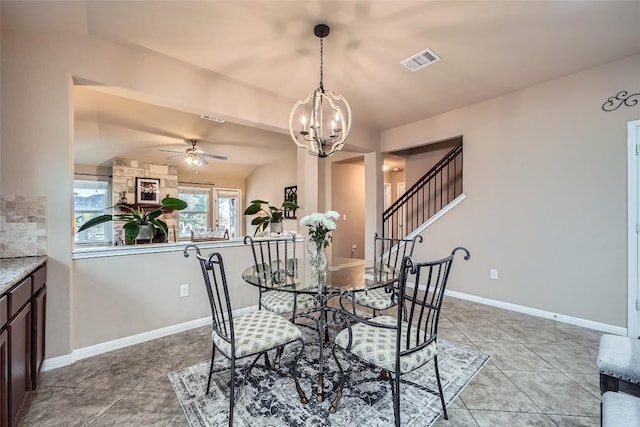 dining room with vaulted ceiling, light tile patterned flooring, and ceiling fan with notable chandelier