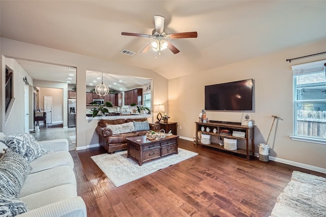 living room featuring ceiling fan with notable chandelier, dark hardwood / wood-style flooring, and lofted ceiling