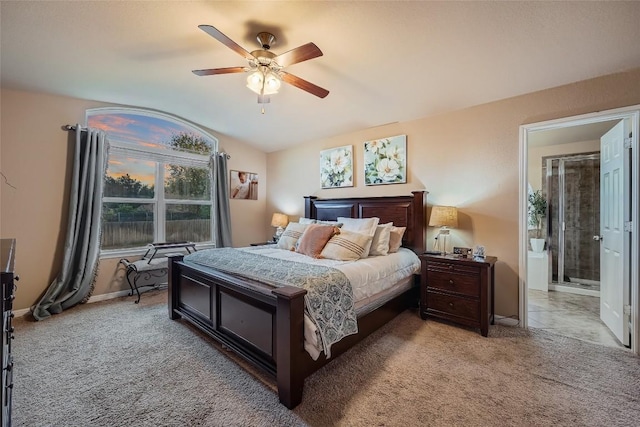 bedroom featuring ceiling fan, light colored carpet, and ensuite bath