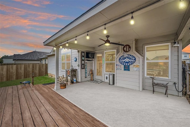 deck at dusk with ceiling fan and a patio