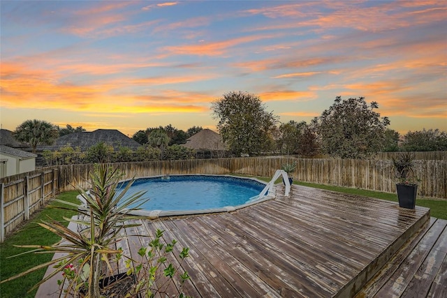 pool at dusk with a wooden deck