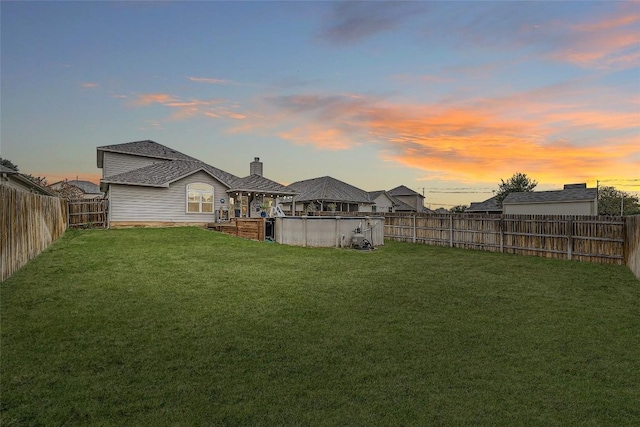 yard at dusk with a fenced in pool