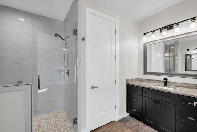 bathroom with vanity, wood-type flooring, and a shower with shower door