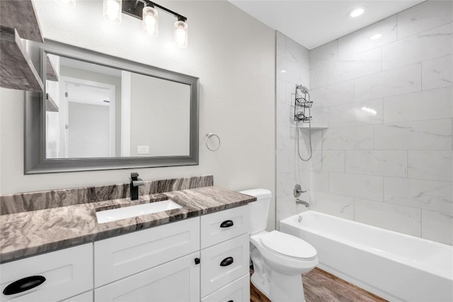 full bathroom featuring vanity, toilet, tiled shower / bath combo, and hardwood / wood-style floors