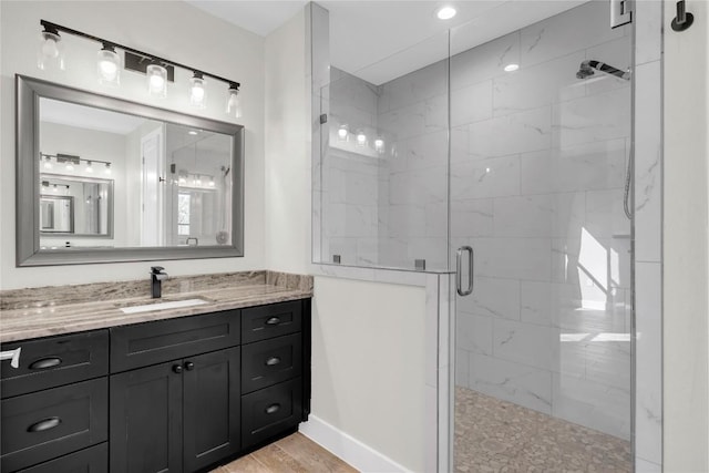 bathroom featuring hardwood / wood-style flooring, vanity, and walk in shower