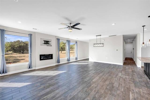 unfurnished living room featuring dark wood-type flooring and ceiling fan