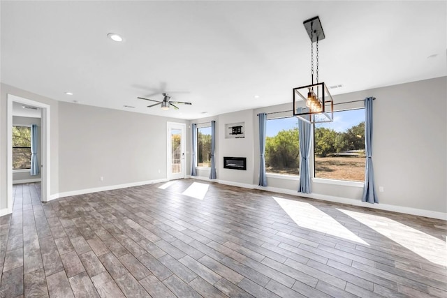 unfurnished living room featuring ceiling fan and hardwood / wood-style floors