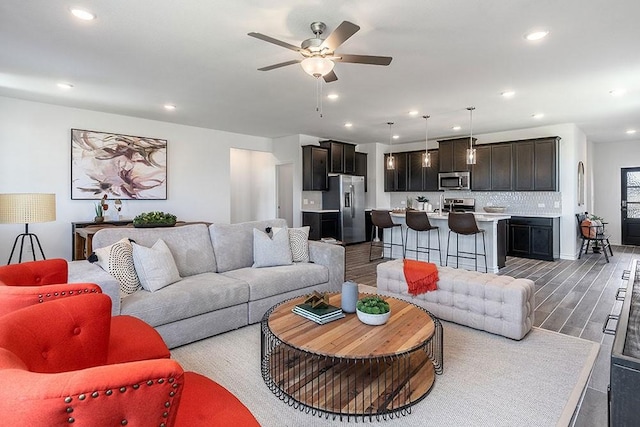 living room with ceiling fan, sink, and dark hardwood / wood-style floors