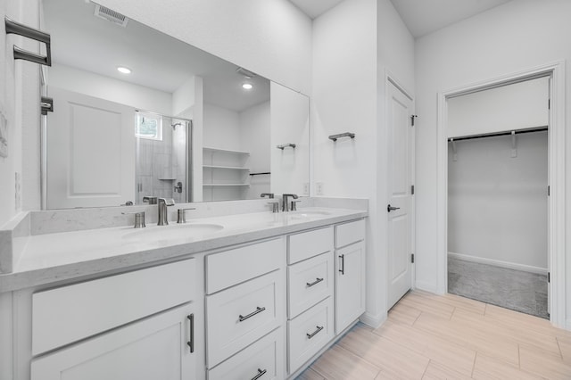 1804 Lorant Ln, Pflugerville, TX 78660 - full bathroom featuring a stall shower, a spacious closet, double vanity, and baseboards