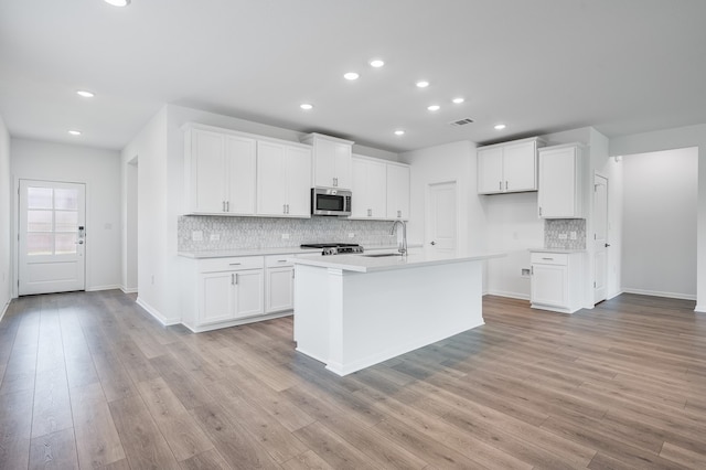 1804 Lorant Ln, Pflugerville, TX 78660 - kitchen featuring stainless steel microwave, tasteful backsplash, recessed lighting, light countertops, and white cabinets