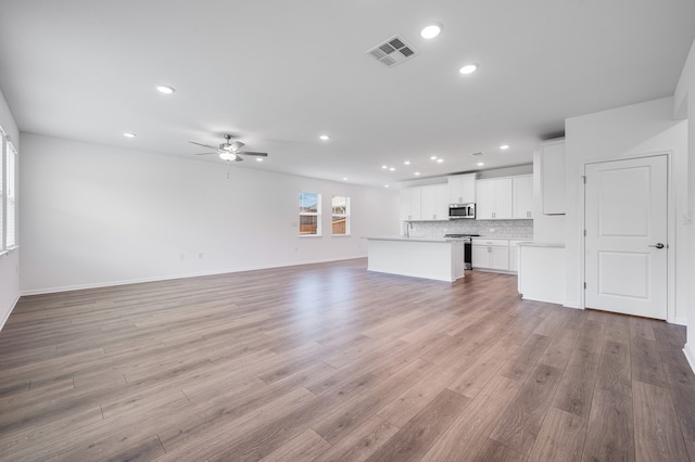 1804 Lorant Ln, Pflugerville, TX 78660 - unfurnished living room with recessed lighting, a ceiling fan, light wood finished floors, and baseboards
