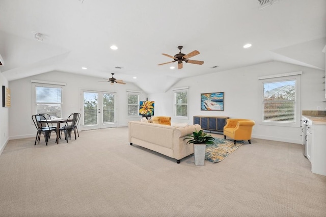 living room with lofted ceiling, light colored carpet, ceiling fan, and a healthy amount of sunlight