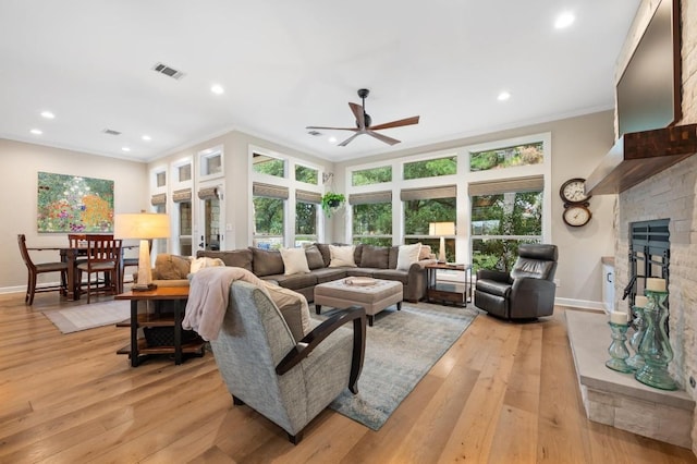 living room with crown molding, a healthy amount of sunlight, and light hardwood / wood-style floors