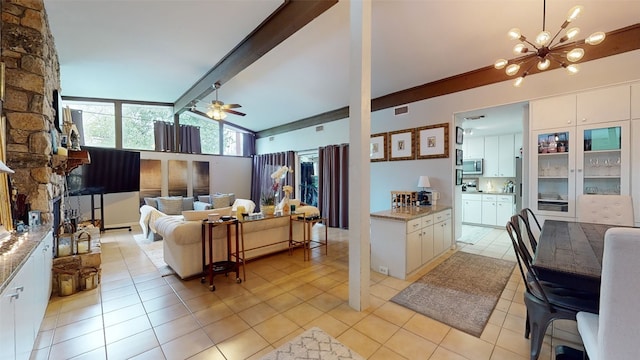 kitchen with white cabinetry, light stone countertops, vaulted ceiling with beams, and light tile patterned flooring