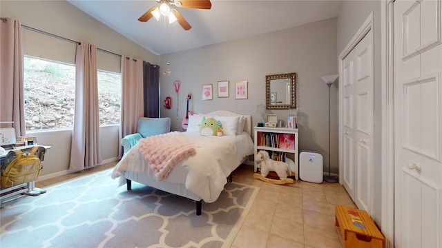 bedroom with vaulted ceiling, ceiling fan, and light tile patterned flooring