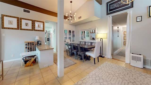 tiled dining room featuring high vaulted ceiling and an inviting chandelier