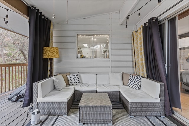 sunroom featuring vaulted ceiling and rail lighting