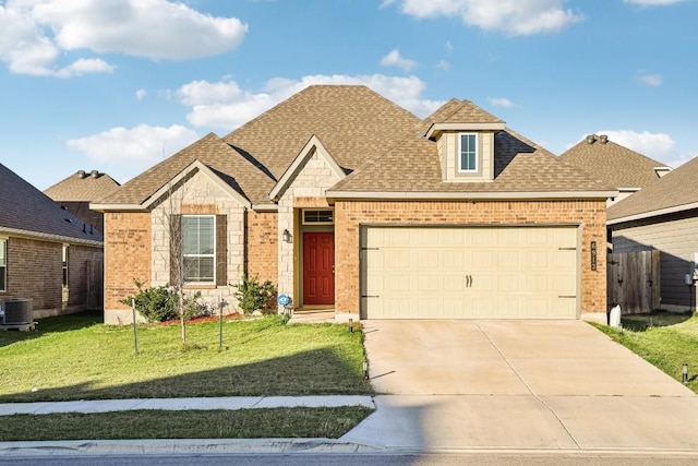 view of front property featuring a garage, central air condition unit, and a front lawn