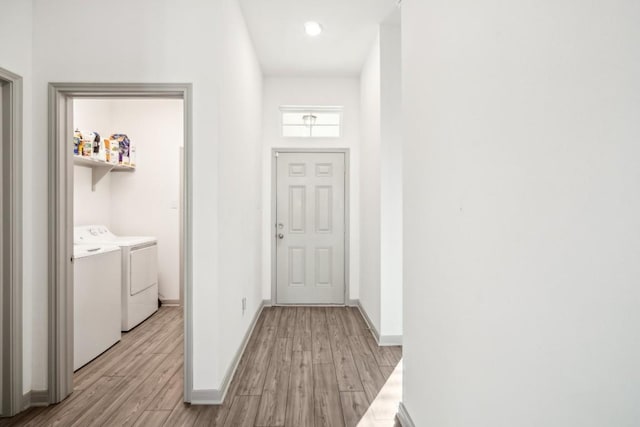 hallway featuring washer and clothes dryer and light hardwood / wood-style floors